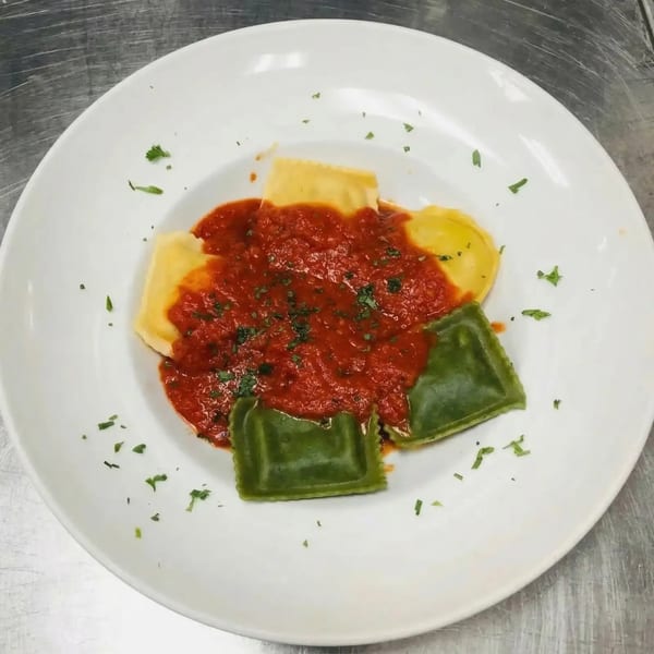 Sal's Famous Pizzeria's ravioli dish with red sauce, featuring both yellow and green pasta.