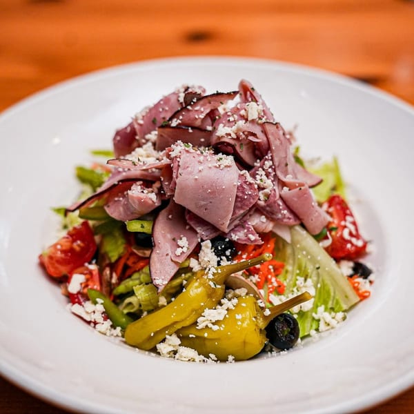 Sal's Famous Pizzeria's Italian salad with ham, feta, olives, tomatoes, and peppers.